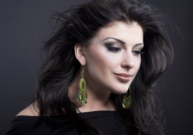 Güzel esmer ile uçan bir saç. Takı güzel bir kızın portresi. Parlak saçlar. Moda. Güzel kadın süsler