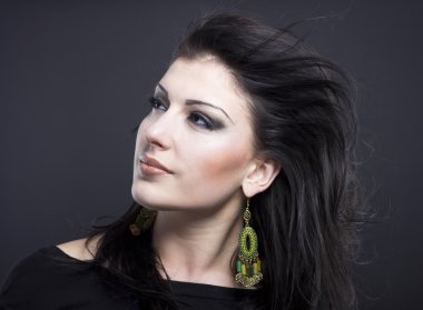 Güzel esmer ile uçan bir saç. Takı güzel bir kızın portresi. Parlak saçlar. Moda. Güzel kadın süsler