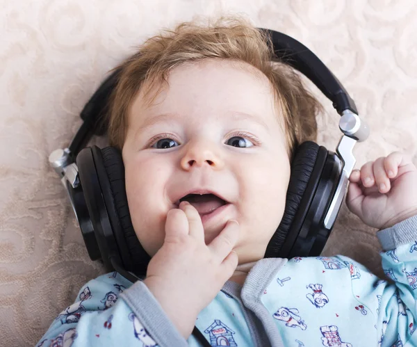 Funny baby i en stora hörlurar. Porträtt av en liten pojke. Söta barn. — Stockfoto