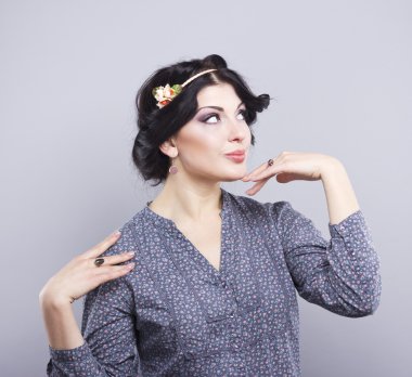 Gri bir arka plan üzerinde güzel esmer. Kirpik uzantıları. Dudak büyütme. tırnak uzatma