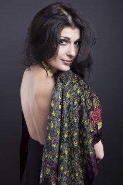 Siyah bir zemin üzerine parlak kıyafetleri çekici esmer. Moda portre. Güzel bir esmer portresi. Parlak işlemeli mendil