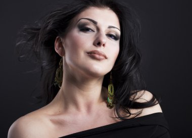 Güzel esmer ile uçan bir saç. Takı güzel bir kızın portresi. Parlak saçlar. Moda. Güzel kadın süsler