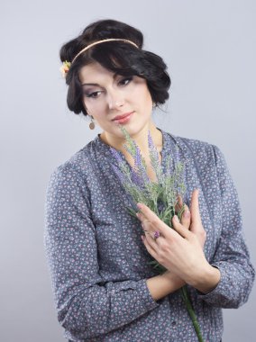 Beautiful brunette with a lavender bush. Portrait of a well-groomed woman