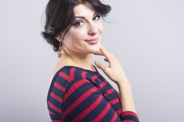 Çizgili bir elbise güzel kız. Siyah bir zemin üzerine esmer gülümseyen. Akıllı kadın portresi