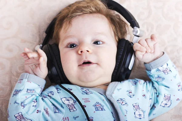 Sjov baby i en stor hovedtelefoner. Portræt af en lille dreng. Sødt barn . - Stock-foto