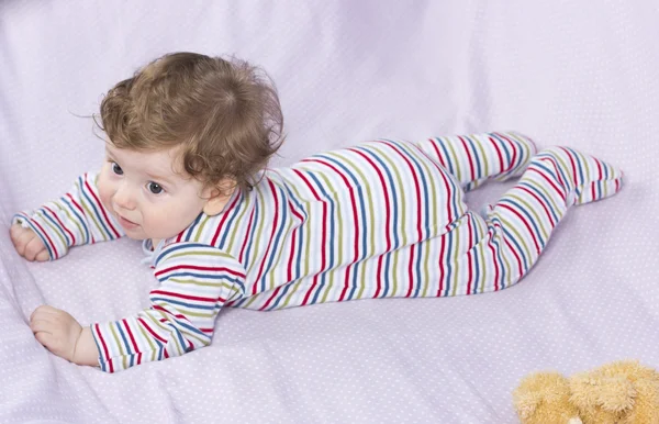 Beautiful baby with a lovely toy. The child in the crib. — Stock Photo, Image