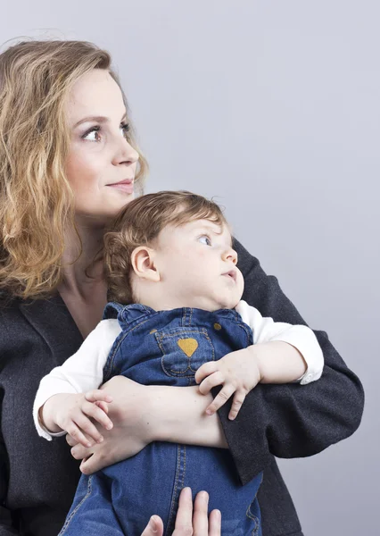 Giovane madre con un bambino tra le braccia. Ritratto di madre e figlio. Bella bionda . — Foto Stock