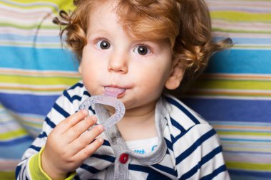 Dişlerini tırmalamak çocuk. Güzel güzel bir oyuncak bebekle