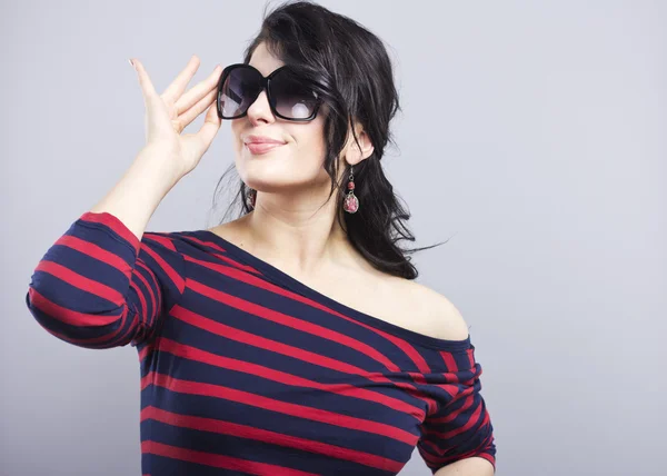 Beautiful brunette in sunglasses. Young girl in a striped dress — Stock Photo, Image