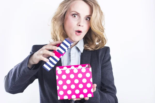 Mulher de negócios feliz com um presente. Retrato de uma loira em uma jaqueta em um branco . — Fotografia de Stock