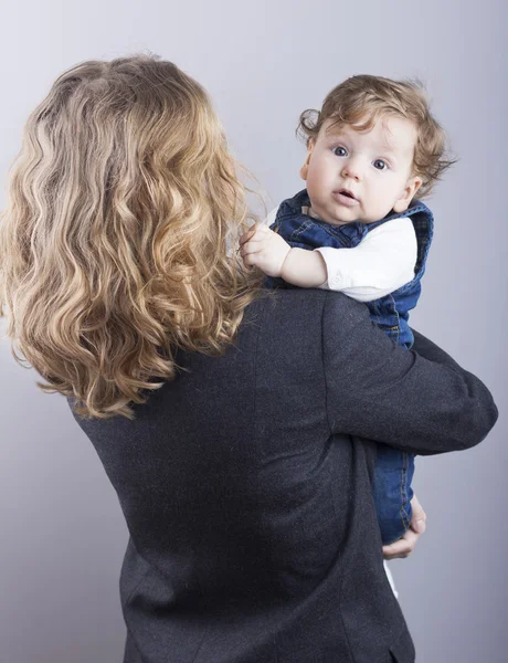 Bella bionda con il suo piccolo figlio sulle mani. Donna d'affari felice. Vita familiare. Bambini. Giovane madre — Foto Stock