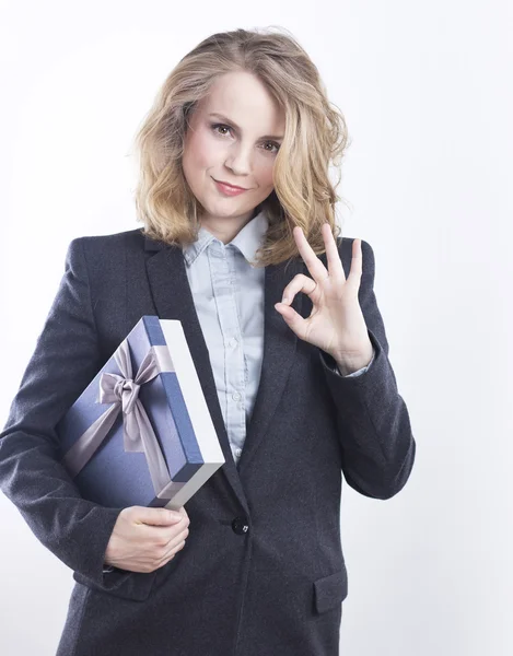 Happy business woman with a gift. Portrait of a blonde in a jacket on a white. — Stock Photo, Image