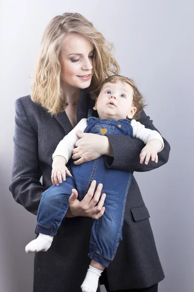 Красивая блондинка с маленьким сыном на руках. Счастливая деловая женщина. Семейная жизнь. Детей. Молодая мать — стоковое фото