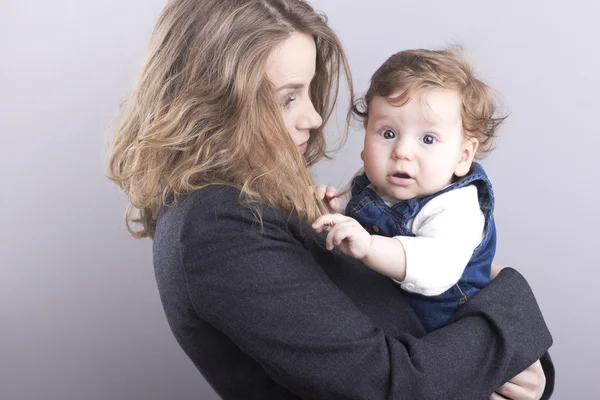 Bella bionda con il suo piccolo figlio sulle mani. Donna d'affari felice. Vita familiare. Bambini. Giovane madre — Foto Stock