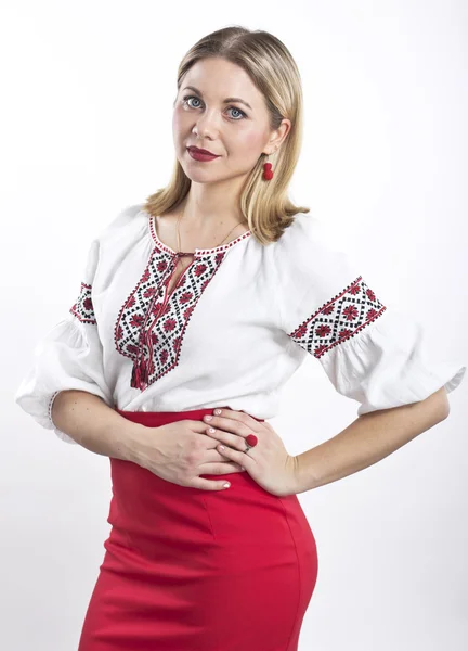 Mujer rubia joven con camisa bordada ucraniana. Hermosa chica en una blusa y falda roja — Foto de Stock