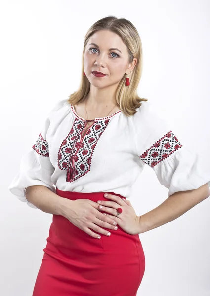 Ung blond kvinna i ukrainska broderad skjorta. Vacker flicka i en blus och röd kjol — Stockfoto