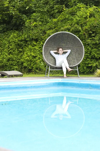 La hermosa rubia relajándose cerca de la piscina. La joven del spa. Hermosa mujer sonriente en una camisa azul . —  Fotos de Stock