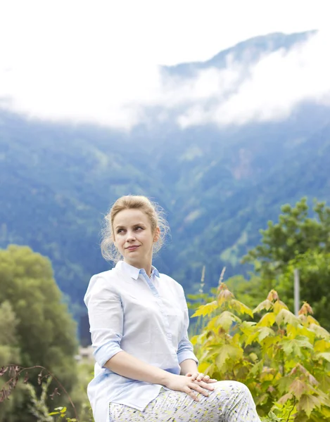 Beautiful young girl on the nature in the highlands. Young girl outdoors alone. Dreamy girl sitting near the country house — Stock Photo, Image