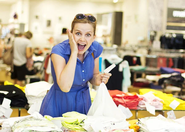 Young girl chooses clothes in a supermarket. A large clothing store. Seasonal sale..The girl in the shop — Stock Photo, Image