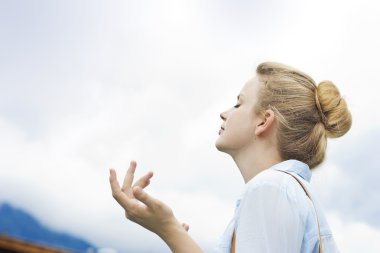 Güzel sarışın mavi gökyüzü arka plan üzerinde. Doğanın keyfini güzel kız. Taze dağ hava solumak