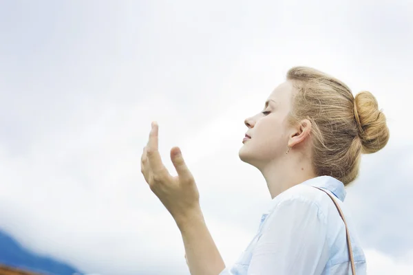 Loira bonita em um fundo de céu azul. Menina bonita apreciando a natureza. Respirando o ar fresco da montanha — Fotografia de Stock