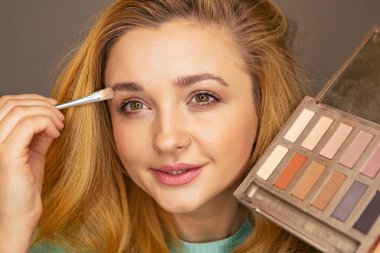 Genç bayan makyaj yapıyor.