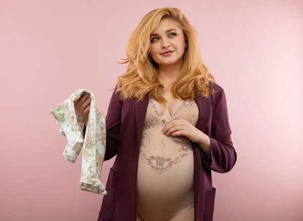 Beautiful Pregnant Woman Holds Baby Clothes — Stock Photo, Image