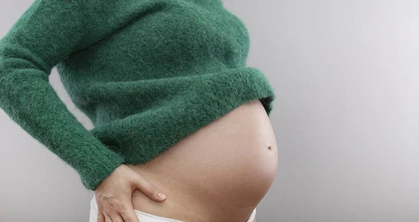 Mulher Grávida Uma Camisola Verde Está Segurando Sua Barriga — Fotografia de Stock