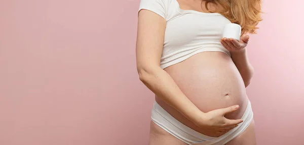 Vrouw Houdt Haar Buik Met Body Cream Haar Hand — Stockfoto