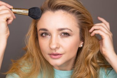 Genç kadın makyaj yapıyor. Makyaj blogcusu kamera önünde dekoratif kozmetik testleri yapıyor