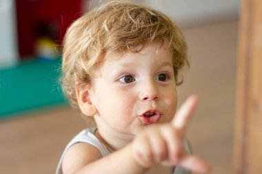 Evdeki bir çocuğun portresi. Küçük çocuk ailesiyle konuşuyor. 