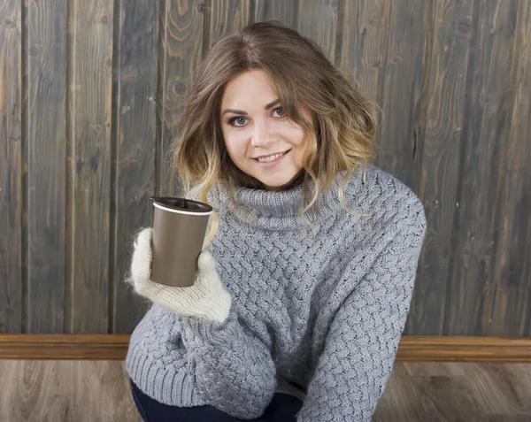 穿着一件暖和的毛衣和一杯咖啡的微笑女孩 — 图库照片