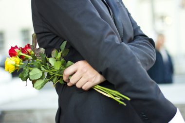 acımasız adam siyah takım elbise ve bir buket gül elinde beyaz gömlek