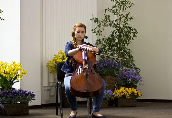 Jeune fille jouant du violoncelle dans un grand hall lumineux. Portrait belle fille aux cheveux longs. Instruments de musique — Photo