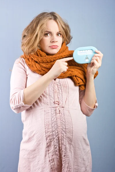 Jonge zwangere vrouw meet de temperatuur in de kamer. Kinder kamerthermometer — Stockfoto