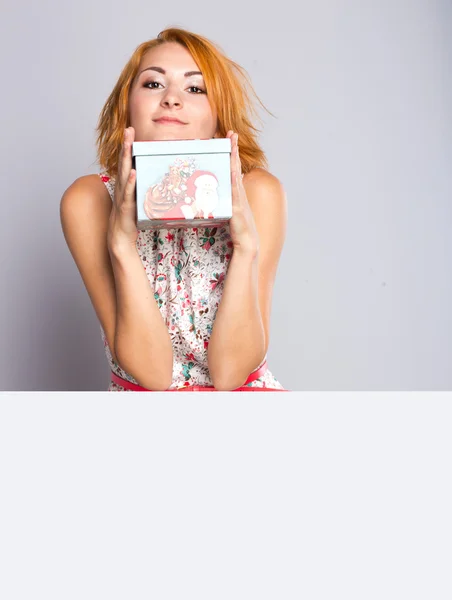 Menina ruiva bonita com caixa de presente nas mãos. Retrato de menina bonita em um vestido curto — Fotografia de Stock