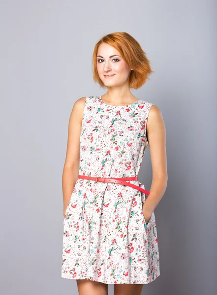 Vacker ung flicka i en kort klänning. Porträtt av en snygg rödhårig tjej i studio — Stockfoto