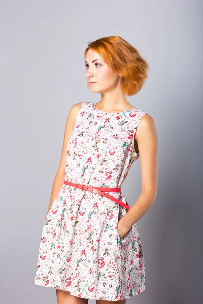 Beautiful young girl in a short dress. Portrait of a stylish red-haired girl in studio — Stock Photo, Image