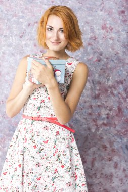 Hediye kutusu elinde güzel kızıl saçlı kız. Kısa bir elbise güzel genç kız portresi