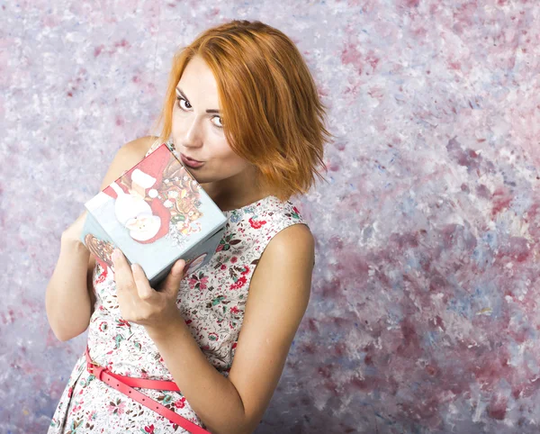 Vacker rödhårig tjej med presentask i händer. Porträtt av vacker ung flicka i en kort klänning — Stockfoto