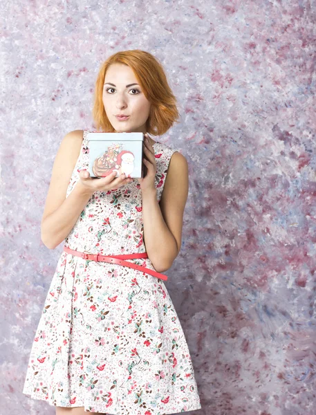 Hermosa chica pelirroja con caja de regalo en las manos. Retrato de una hermosa joven en un vestido corto — Foto de Stock