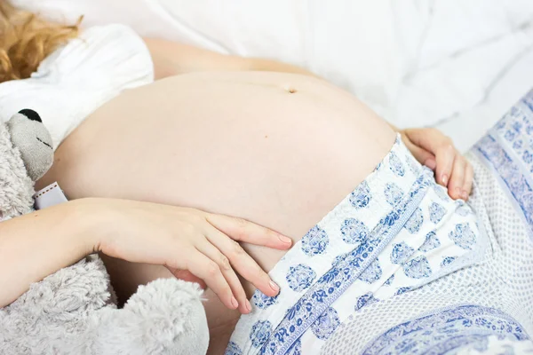 Linda loira grávida acariciando sua barriga — Fotografia de Stock