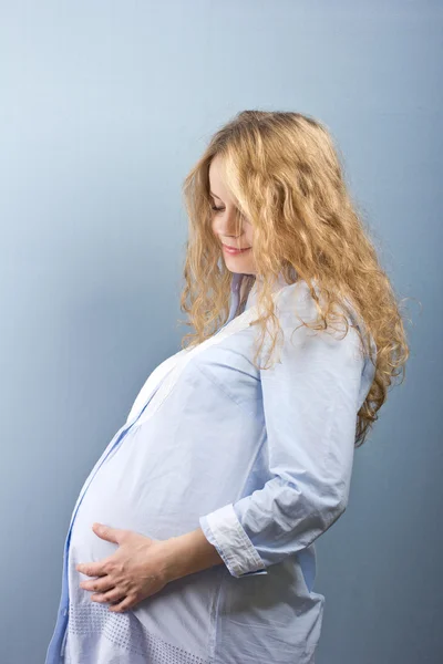 Красивая беременная блондинка гладит живот — стоковое фото
