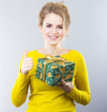 Beautiful blonde holding a gift. Gift on the day of lovers. Gift for women. Portrait of beautiful girl
