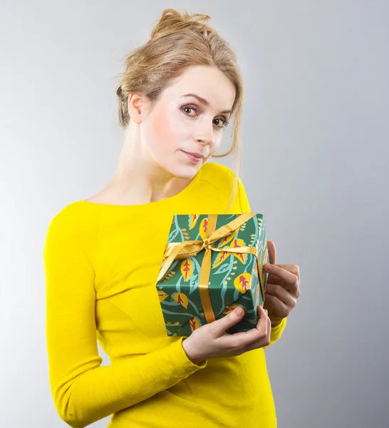 Vacker blondin innehar en gåva. Presentkort på dagen för älskare. Present till kvinnor. Porträtt av vacker flicka — Stockfoto
