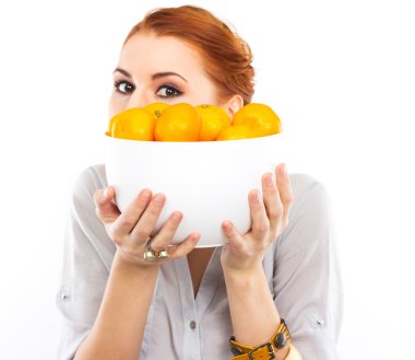 Sulu mandalina sepeti tutan genç kız. Mutlu kız portresi. Mandalina derin beyaz bir tabak içinde