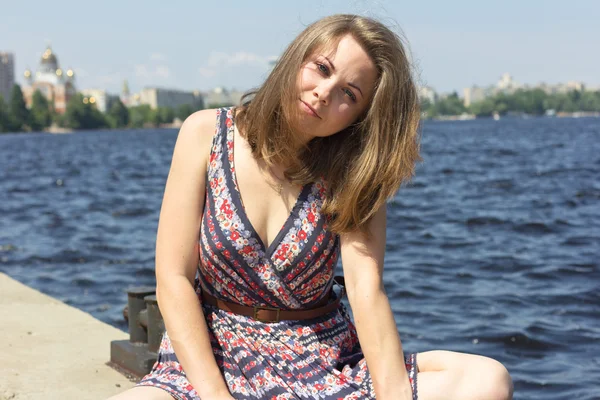 Bonita chica de ojos azules disfrutando del sol y el buen tiempo cerca del agua.Hermosa chica sonriente relajándose en la naturaleza. Retrato al aire libre. Rostro de una hermosa joven — Foto de Stock