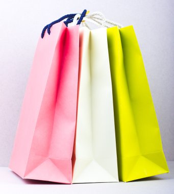 Gri bir arka plan üzerinde üç parlak paketleri. Alışveriş. satın alma