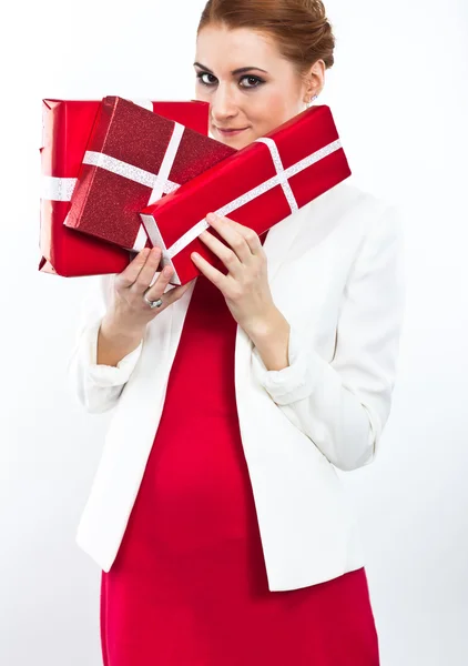 Jeune fille en robe rouge avec cadeau boîte rouge. Belle fille aux cheveux roux sur blanc . — Photo
