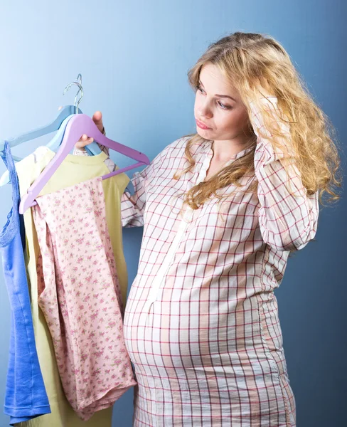 Schöne schwangere Blondine wählt Kleidung. Porträt einer schwangeren Frau. Mode portrait.woman Paar Shopping Portrait. — Stockfoto